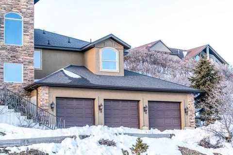 Dormer window over three door garage of home on a snowy neighborhood in winter Stock Photos