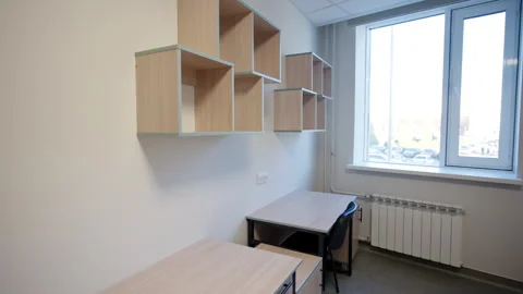 Dormitory features wooden desks and minimalist wall cubbies Stock Footage 332736984