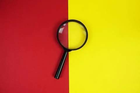 Do's And Don'ts text with magnifying glass on red and yellow  background Stock Photos