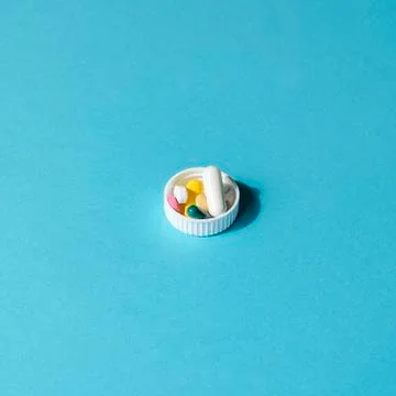 Dose of the colored pills in the cap of the package of pills Stock Photos