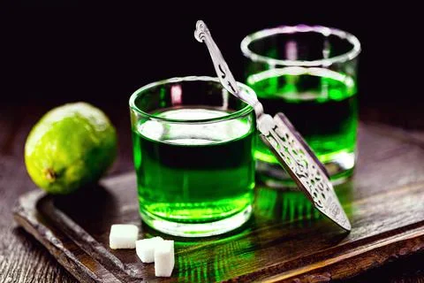 Doses of absinthe with brown sugar cubes. distillate of absinthe in a glass a Stock Photos