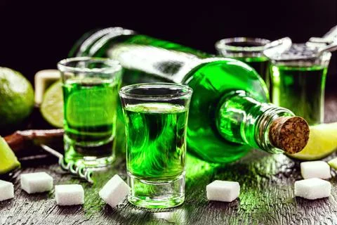 Doses of absinthe with sugar cubes. Absinthe bottle, green distilled drink Stock Photos