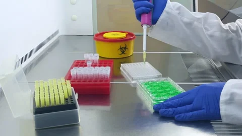 Doses the liquid with a pipette between laboratory tablets Stock Footage 241095208