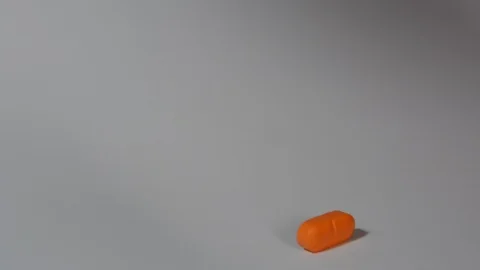 Dosing, halve orange pill  with a knife Видео 113875934