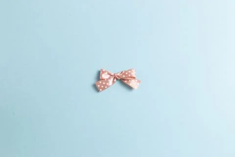 Dot pattern pink bow ribbon isolated on sky blue background Stock Photos