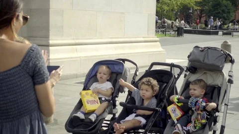 Doting mothers taking pictures of babies in strollers Washington Square Park NYC Vídeo Stock 80965281