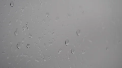 Dots of wet drops on window in cloudy weather falling doun Stock Footage 98497066