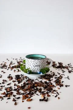 Dotted mug on a white table with leafs and white background Stock Photos