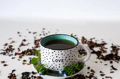 Dotted mug on a white table with leafs and white background Stock Photos