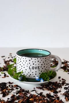 Dotted mug on a white table with leafs and white background Stock Photos