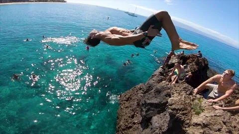 Double backflip cliff jump in ocean Maui Hawaii Black Rock Stock Footage
