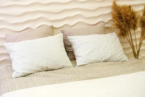 Double bed in the bedroom interior made in warm colors and smooth lines Stock Photos
