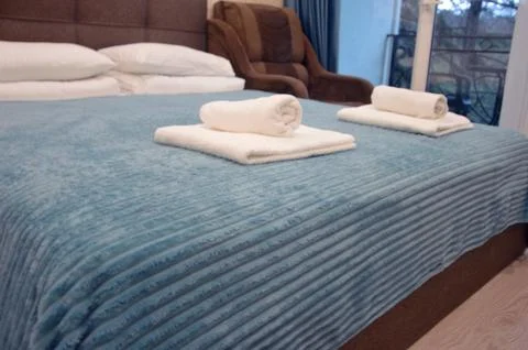 Double bed with brown headboard, turquoise bedspread and white pillows in h.. 写真素材