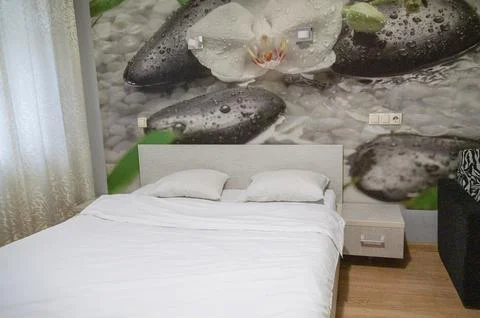 Double bed with pillows and light from the window. Stock Photos