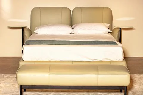 Double bed with a soft leather headboard and mirrored bedside shelves on th.. Stock Photos