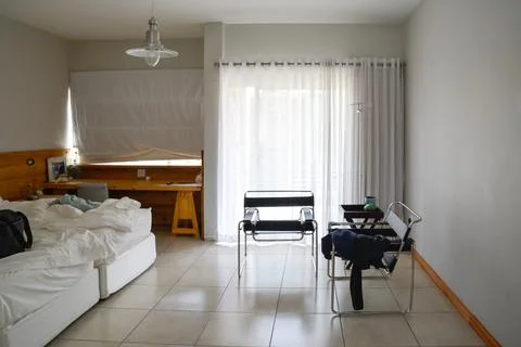 A double bed spread out with white blankets in a hotel room or apartment Stock Photos