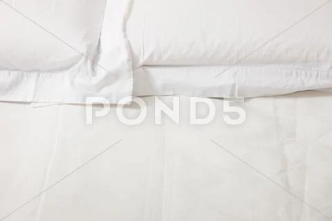 Double bed with white linens Stock Photos