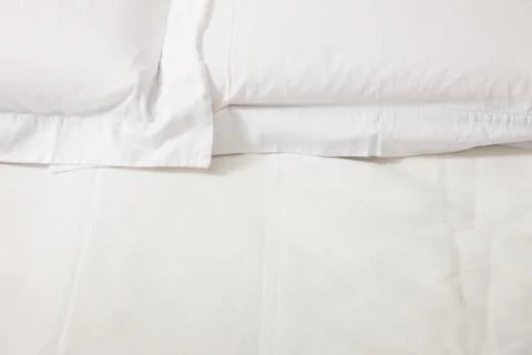 Double bed with white linens Stock Photos