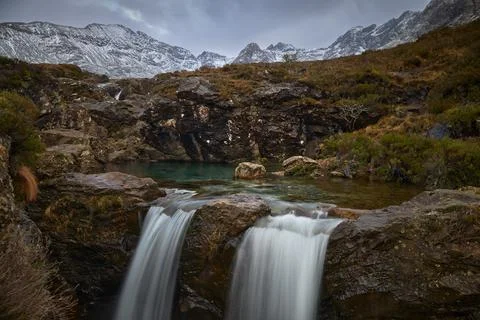 Double cascade with turquoise water between idyllic landscape of mountains wi Stock Photos