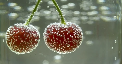 Double cherry in glass of water with bubbles Stock Footage 100146029