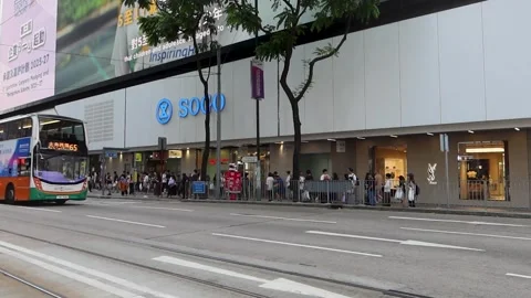 A double decker bus and car pass by Stock Footage 313486493