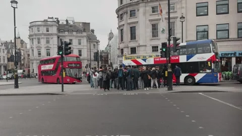 Double-Decker Bus and Open-top Tours as Pedestrians cross at City Intersection Video stock 335538809