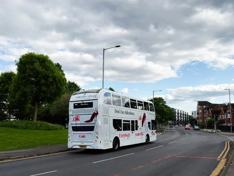 Double decker bus with Coca Cola advertising on a suburban street in Manche.. Stock Photos