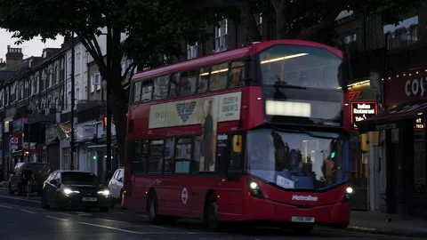 Double decker bus driving in early evening in shopping street. London, UK. Stock Footage 217487236