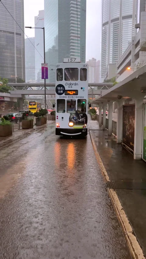 Double-decker bus navigating through rainy city streets with Stock Footage 280199673