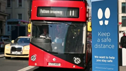 Double Decker bus passes a social Distancing sign Vidéo 169452403