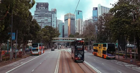 Double-decker buses and trams driving on Hong Kong city street Video stock 330512918