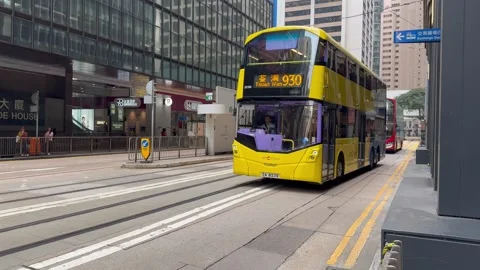 Double decker buses passing by Exchange square Hong Kong Stock Footage 273189849