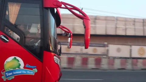 A double-decker tour bus drives along the highway in the early evening Stock Footage 276148533