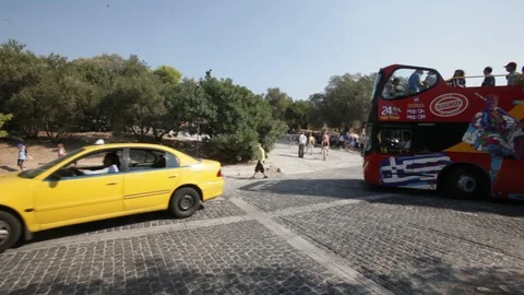 Double-decker tourist bus passing in front of the Acropolis Stock Footage 87099472