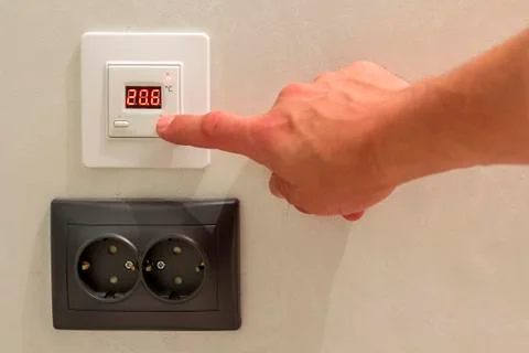 Double electric isolated socket and thermostat installed on light yellow plas Stock Photos