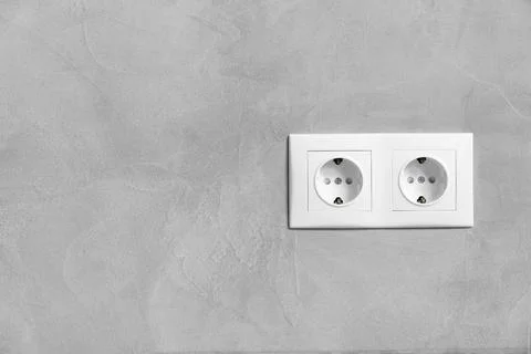 Double electrical outlet on a gray wall copy space Stock Photos