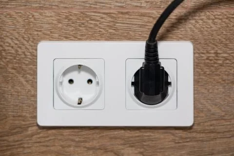 Double electrical outlet with plug inserted Stock Photos