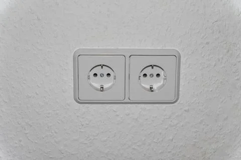 Double electrical socket (European standard) on a light wall. Stock Photos