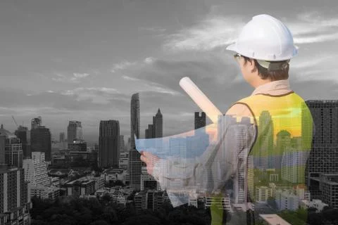 Double exposure of construction engineer checking construction drawing 스톡 사진