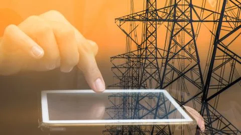 Double exposure of hand using tablet with high voltage tower background Stock Photos