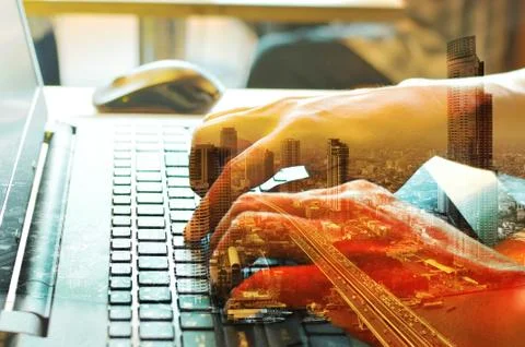 Double Exposure of Man using Laptop with Cityscape Stock Photos