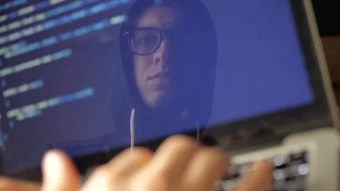 Double Exposure: A programmer developer in the hood and glasses writes the Stock Footage 103815104
