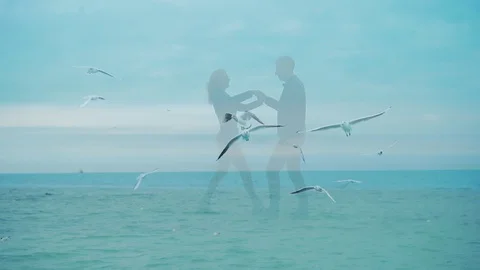 Double exposure. Slow motion. Young loving couple silhouette over the sea waves  Stock Footage 128505376