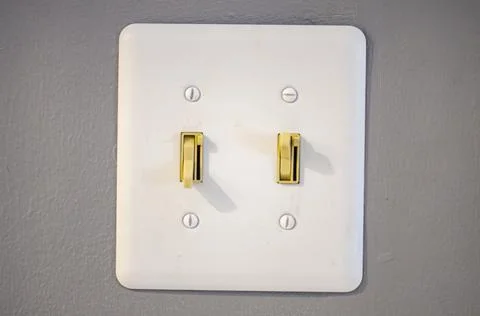 Double light switch with off white handles on gray wall Stock Photos