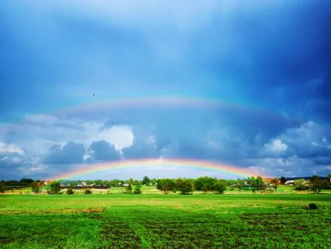 Double rainbow after a thunderstorm over a green field Foto stock