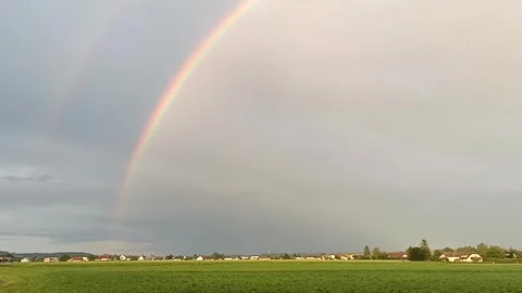 A double rainbow against cloudy gray sky Stock Footage 276281018