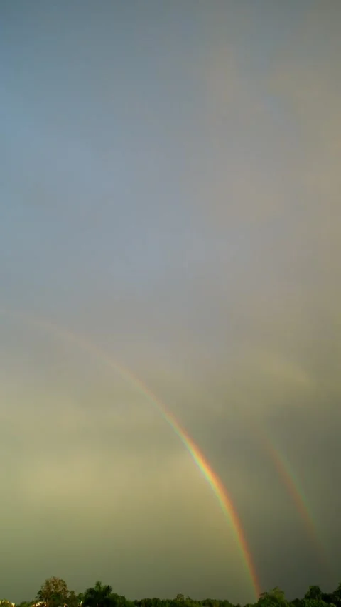 Double rainbow and rainy clouds on sky at sunset. Tropical island. Stock Footage 277066132