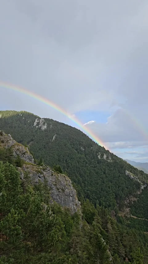 Double rainbow arches over forested slopes of Storžič in Slovenia after a Stockbeeldmateriaal 347038124