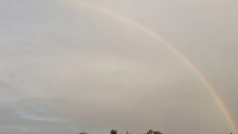 Double Rainbow In the Grey Sky and Green Trees In The Village Panorama Stock Footage 106417889