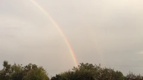 Double Rainbow In the Grey Sky and Green Trees In The Village 8 Stock Footage 106417921